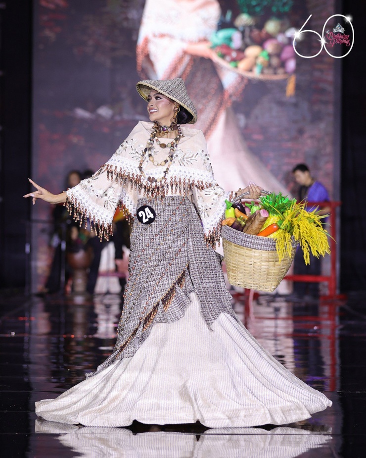 Trang phục của thí sinh Monica Acuno đến từ Kalayaan, Laguna. Bộ trang phục bày tỏ lòng tôn kính đối với những người nông dân cần cù ở quê hương cô bằng cách trưng bày các loại trái cây và rau quả tươi được xếp trong giỏ.