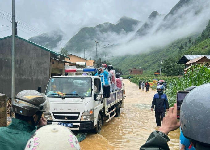 CSGT hỗ trợ khách du lịch kẹt ở Hà Giang trong đợt mưa lũ hôm 9/6. Ảnh: Gia Chính