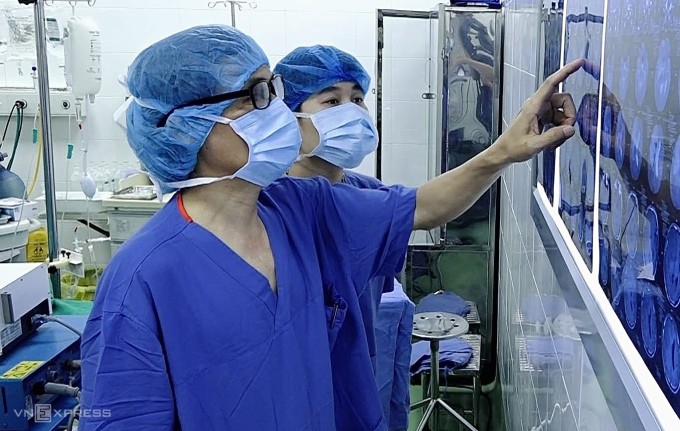 Bác sĩ Hệ và đồng nghiệp đang quan sát phim của bệnh nhân. Ảnh: Thùy An