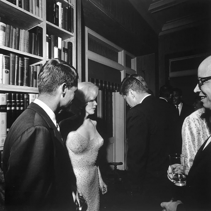 Marilyn Monroe đứng cạnh hai anh em nhà Kennedy trong bữa tiệc sinh nhật cựu Tổng thống Mỹ John F. Kennedy và em trai Robert F. Kennedy vào tháng 5/1962. Ảnh: Getty Images.