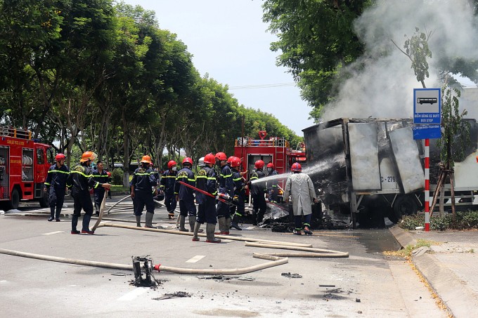 Lực lượng cứu hỏa nỗ lực dập lửa, nhưng tài sản trên xe đã bị thiêu rụi. Ảnh: Ngọc Trường