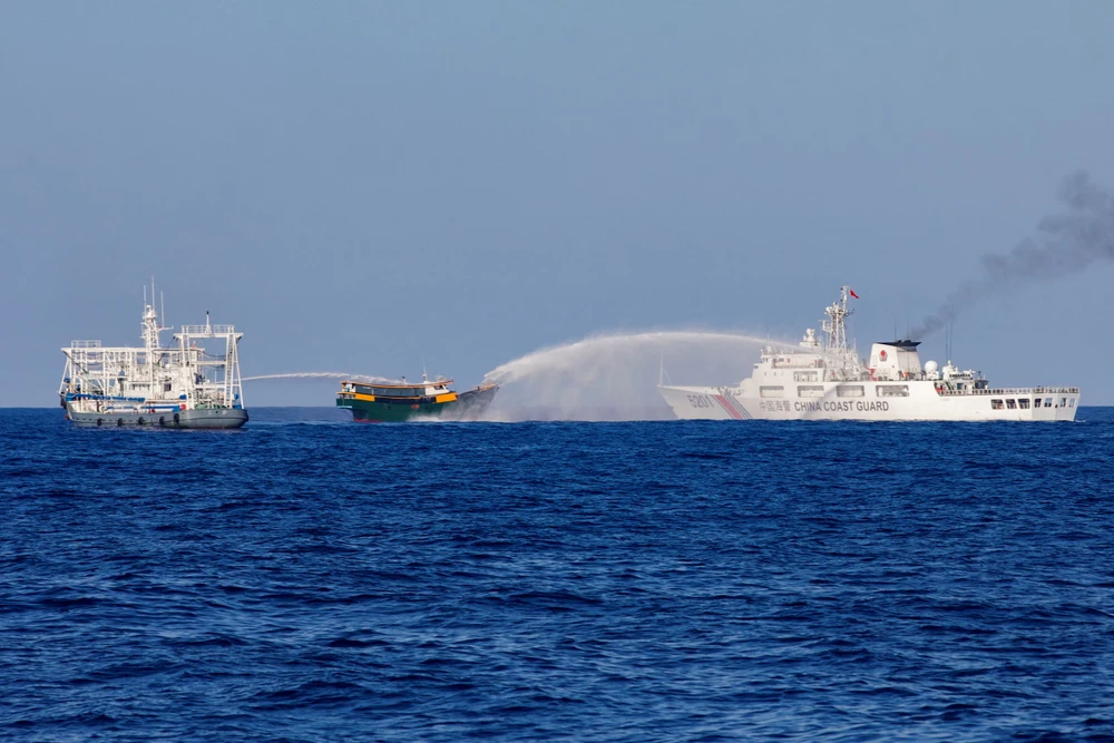 Tàu hải cảnh Trung Quốc phun vòi rồng vào tàu Philippines trên Biển Đông hồi tháng 3. Ảnh: REUTERS