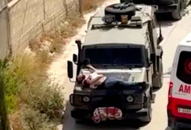 Hình ảnh người đàn ông bị trói trên mũi xe jeep được chụp từ video ghi lại sự việc.