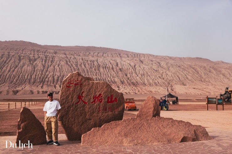 Du khách tạo dáng bên phiên đá có khắc dòng chữ "Hỏa Diệm Sơn".