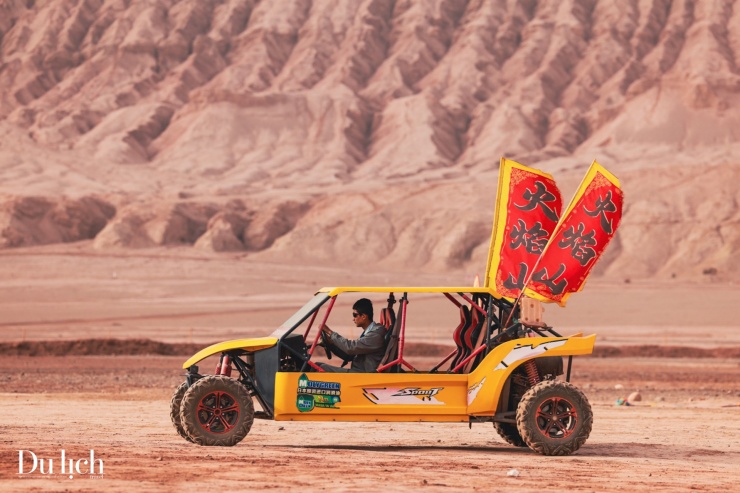 Xe vượt địa hình đưa du khách chiêm ngắm vẻ đẹp hoang mạc sa thạch đỏ tại Hỏa Diệm Sơn.