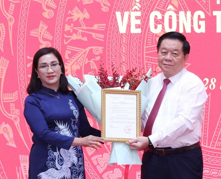 Trưởng Ban Tuyên giáo Trung ương Nguyễn Trọng Nghĩa trao quyết định cho bà Đinh Thị Mai. Ảnh: TTXVN