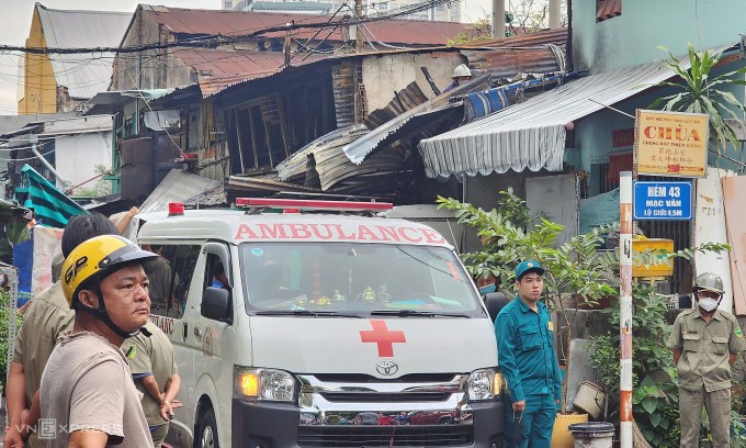 Xe cứu thương tại khu vực cháy, căn nhà xảy ra hỏa hoạn nằm sau ôtô, sáng 2/4. Ảnh: Đình Văn