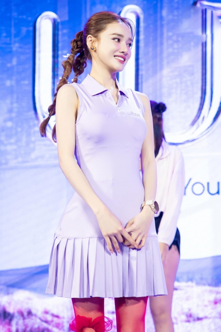 Trong một sự kiện, Nhã Phương mặc váy polo màu tím, kết hợp cùng quần tất xuyên thấu màu đỏ.