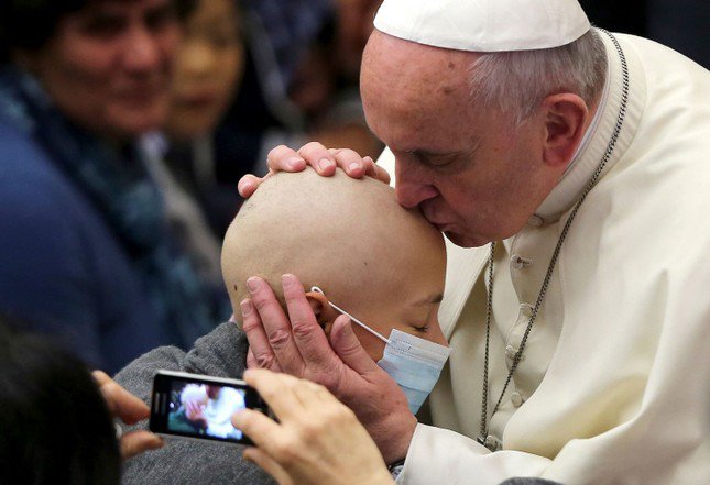 Giáo hoàng hôn trán một bé gái trong buổi tiếp kiến ​​đặc biệt tại Vatican vào tháng 11/2014. (Ảnh: Reuters)
