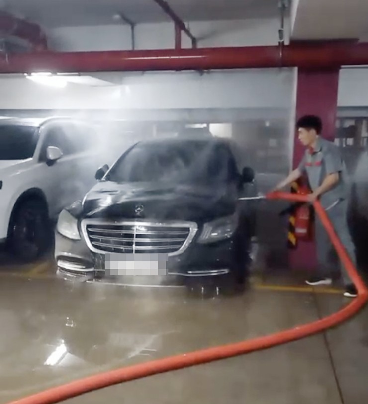 Lực lượng bảo vệ chung cư xử lý vụ cháy xe. Ảnh: Cắt từ clip