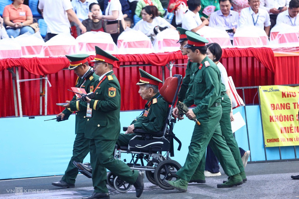Một cựu binh di chuyển bằng xe lăn vào khán đài. Ảnh: Quỳnh Trần