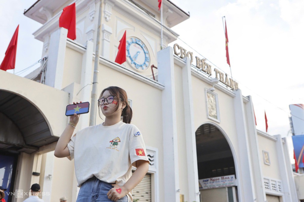 Đinh Ngọc Ánh (24 tuổi) hào hứng chụp ảnh trước chợ Bến Thành. Đến từ 23h đêm, Ánh cho biết cố gắng duy trì năng lượng sẵn sàng để xem diễu binh hôm nay. Ảnh: Khương Nguyễn