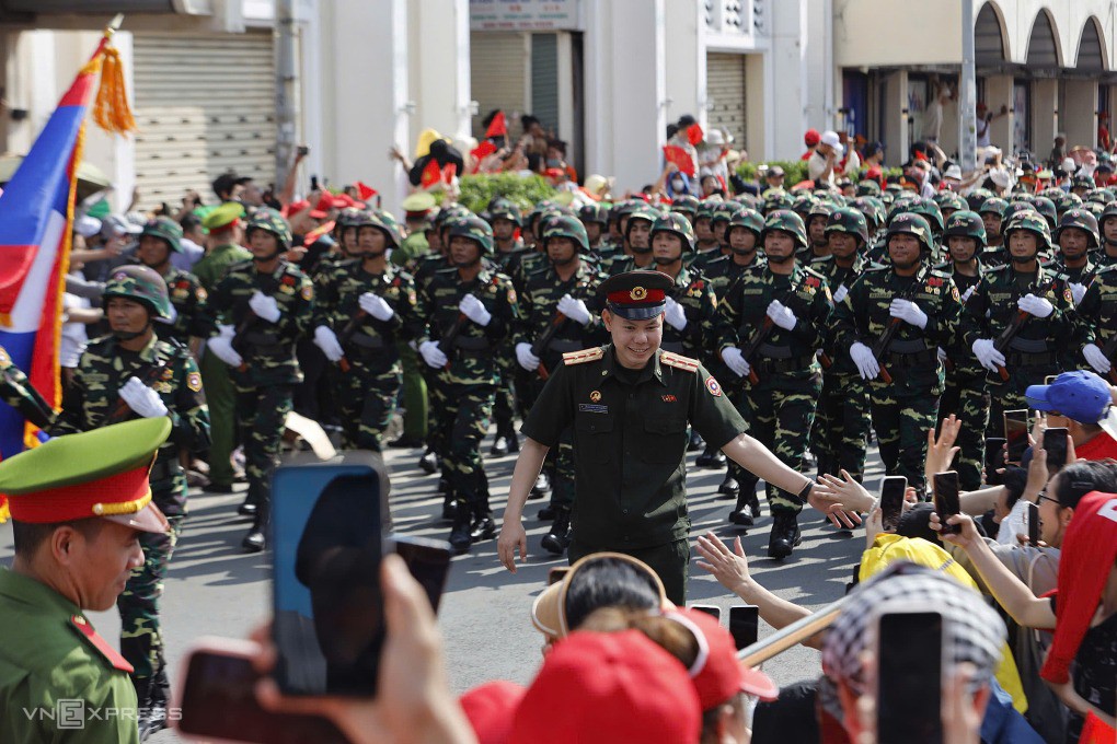 Cán bộ của đoàn Quân đội Lào bắt tay, giao lưu với người dân trên đường tới nơi tập kết