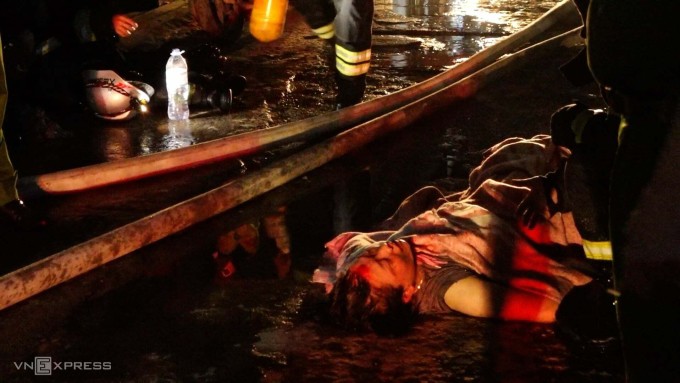 Người vợ bị thương, được đưa ra ngoài đầu tiên. Ảnh:&nbsp;Huy Mạnh