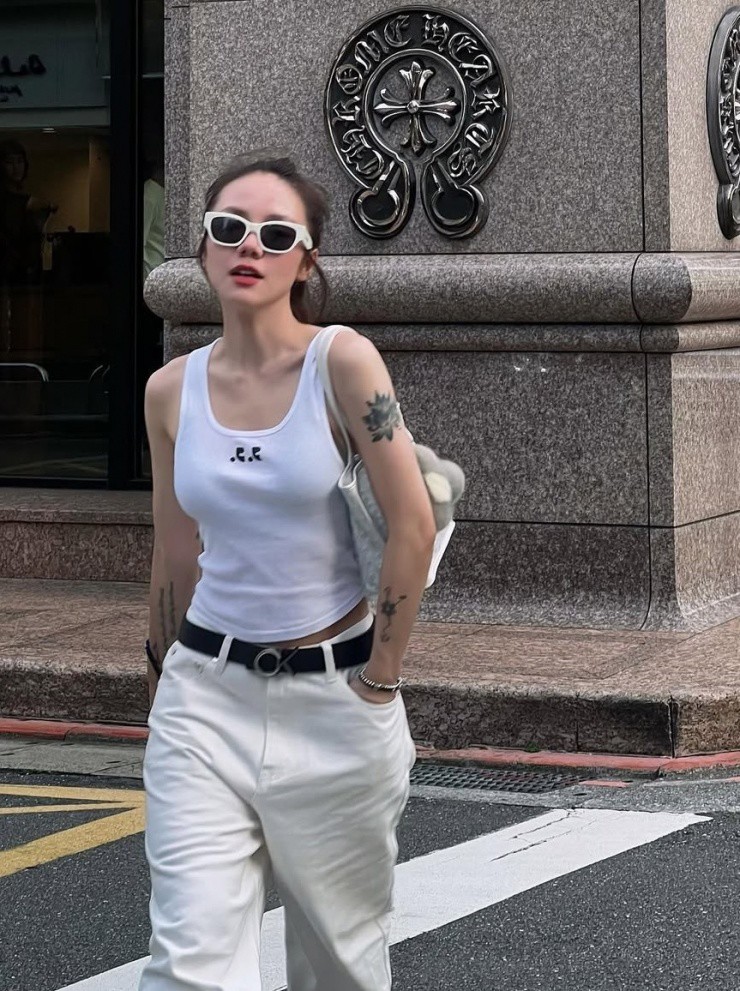 Phương Ly chuộng quần jeans ống rộng, sắm nhiều phiên bản khác màu nhau để tiện phối cùng áo phông hoặc tank top. Để tăng vẻ thời trang, cô luôn mang kính râm.