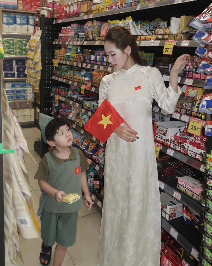 Hòa chung không khí chào mừng 50 năm thống nhất đất nước, một cô gái ở TP HCM diện áo dài trắng và cầm cờ khi đi chơi và mua sắm. Ảnh: Instagram Tuc Anh Hoa