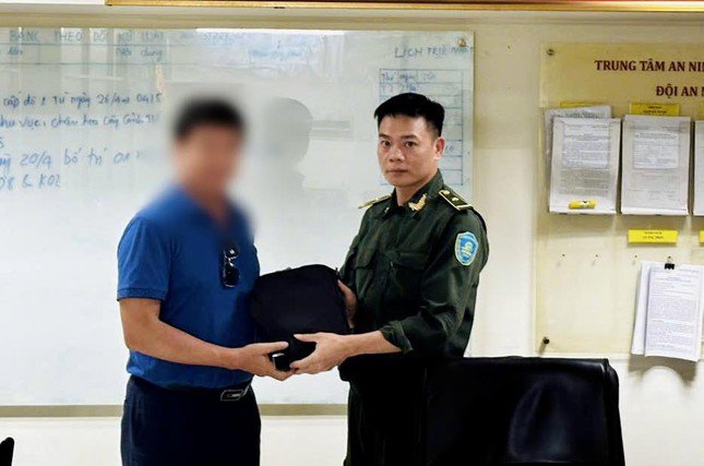Anh V.V.T. nhận lại túi xách chứa gần trăm triệu đồng bị bỏ quên tại Cảng HKQT Nội Bài chiều 2/5. Ảnh: NIA.