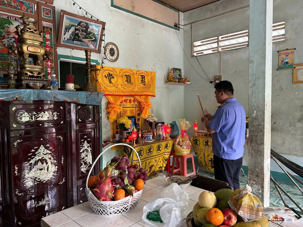 Điều tra viên Cơ quan Điều tra VKSND Tối cao thắp nén nhang trước di ảnh bé Trân và bàn thờ của cha bé vừa được lập vài ngày trước. Ảnh: VY
