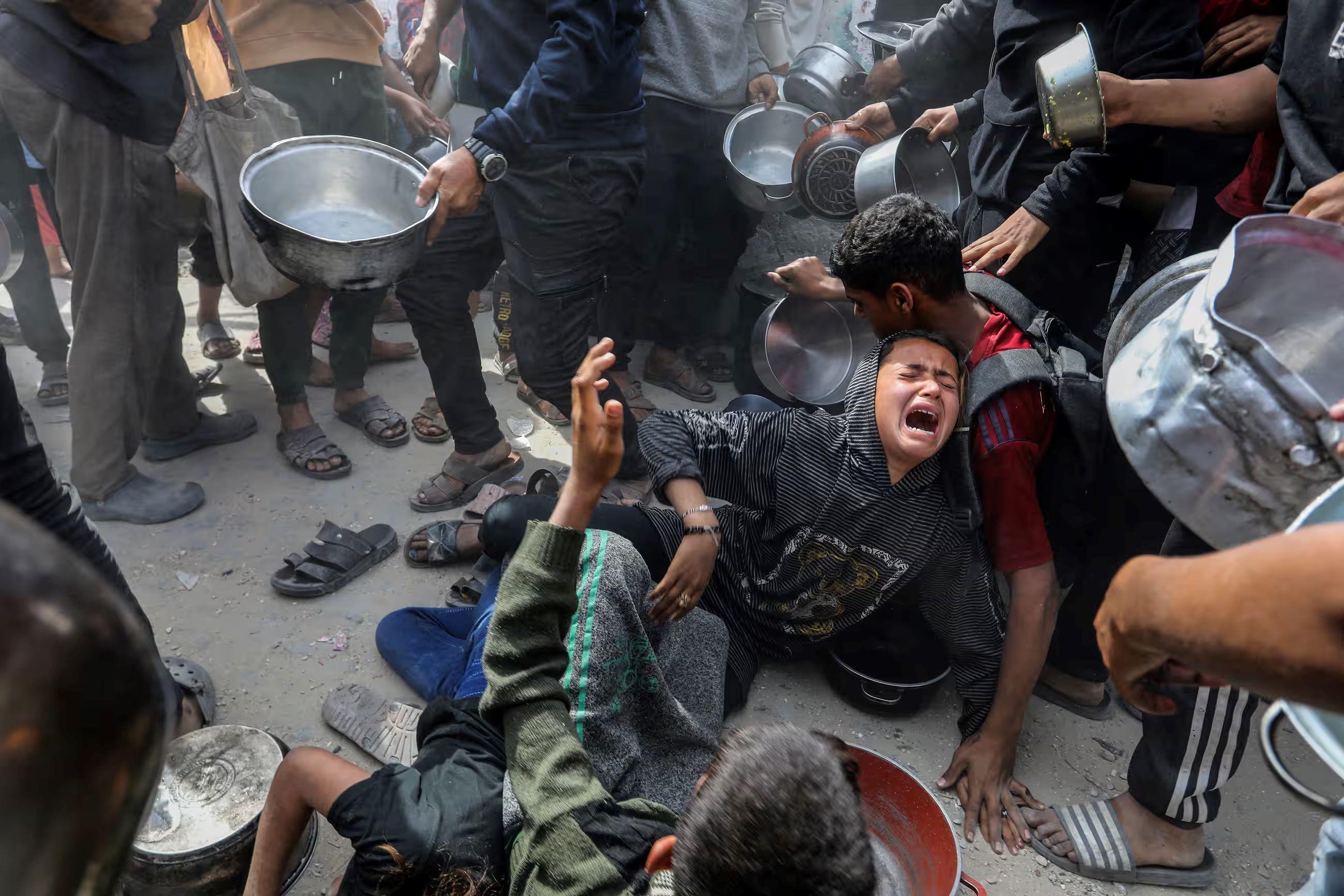 Người dân ở Dải Gaza xô đẩy để nhận lương thực (ảnh: Reuters)