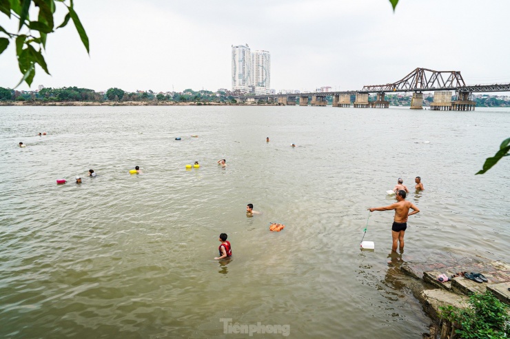 Tương tự, tại bãi tắm sông Hồng ở khu vực gần chân cầu Long Biên cũng thu hút rất đông người đến giải nhiệt.