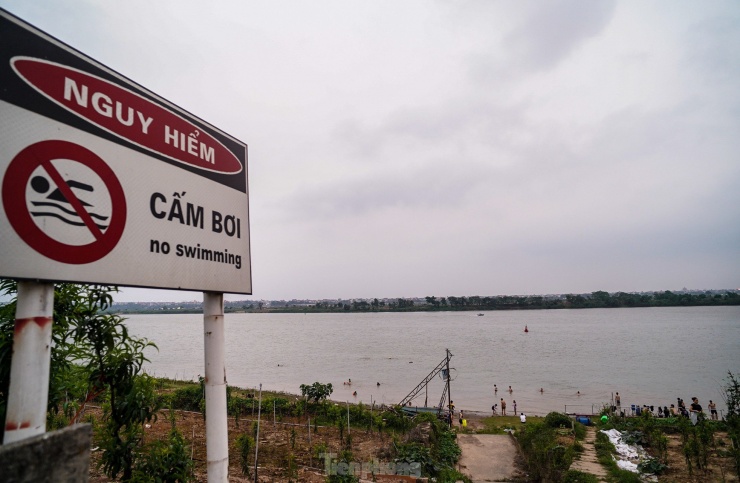 Ở khu vực 2 bên bờ sông Hồng có rất nhiều bãi tắm tự phát như thế này. Mặc dù đã có các biển cảnh báo nguy hiểm, nhiều người vẫn ngó lơ, vẫn tìm đến các khu vực ven sông Hồng để giải nhiệt, đặc biệt là trong những ngày nắng nóng gay gắt.