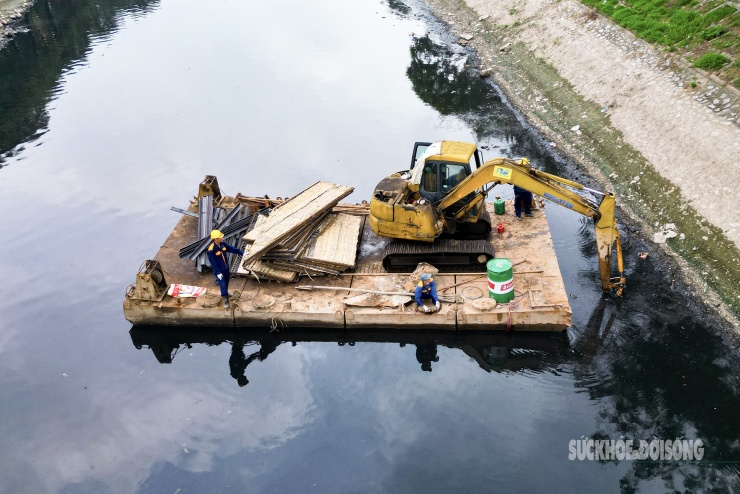 Gần khu vực đập dâng, công nhân tiếp tục nạo vét, khơi thông dòng chảy.