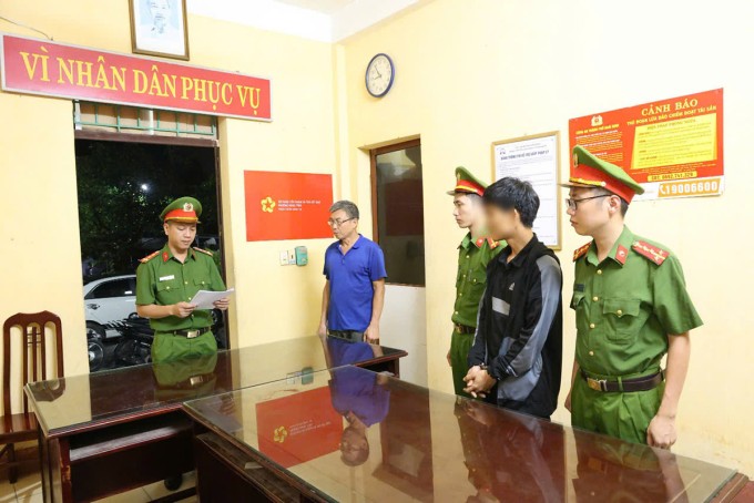 Công an đọc lệnh tạm giữ với nam thanh niên (áo khoác đen, còng tay). Ảnh: Công an Nam Định