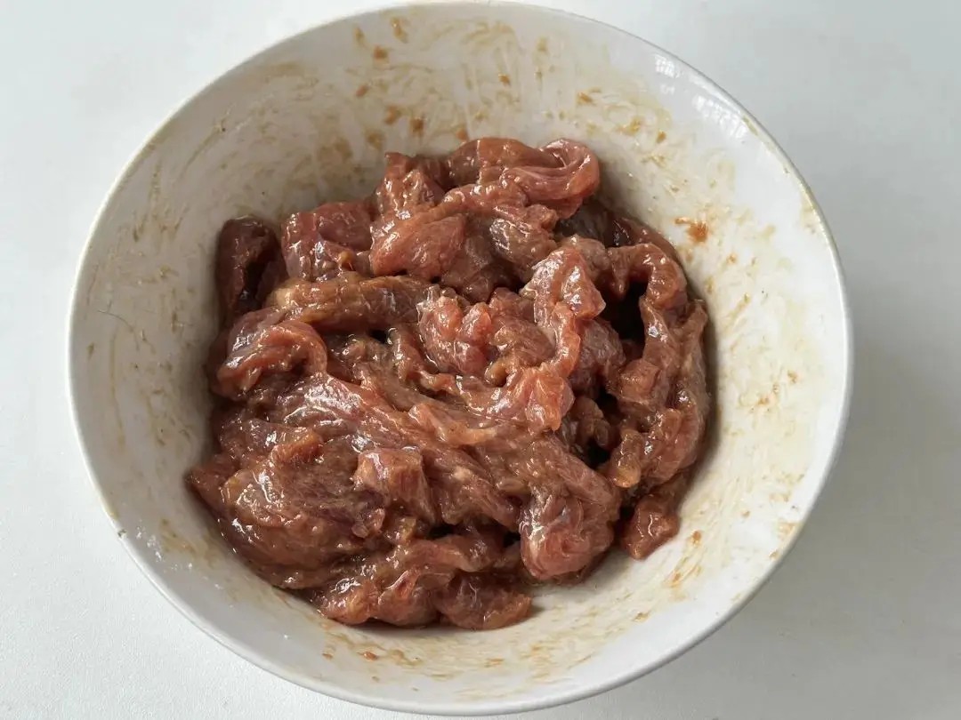&nbsp;Thái thịt bò thành sợi, cho vào tô cùng xì dầu, dầu hào, tiêu trắng, bột gừng, bột bắp, chút baking soda rồi trộn đều tay cho đến khi sánh lại. Cuối cùng thêm ít dầu ăn&nbsp;và bảo quản trong ngăn mát tủ lạnh.