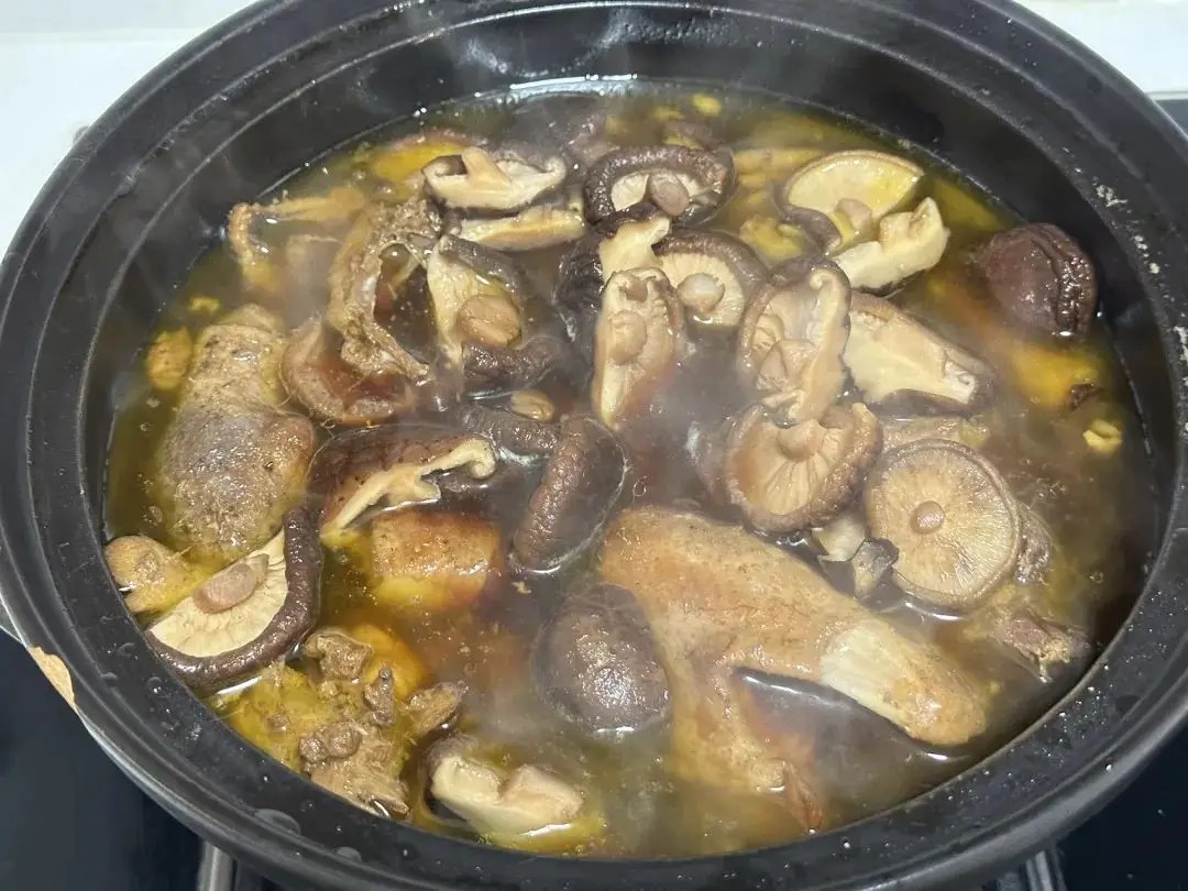 Đổ nước sôi vào ngập mặt gà, sau đó cho nấm hương đã ngâm vào. Đun sôi rồi hạ nhỏ lửa, hầm khoảng 1 tiếng để gà mềm và nước dùng ngọt thanh.