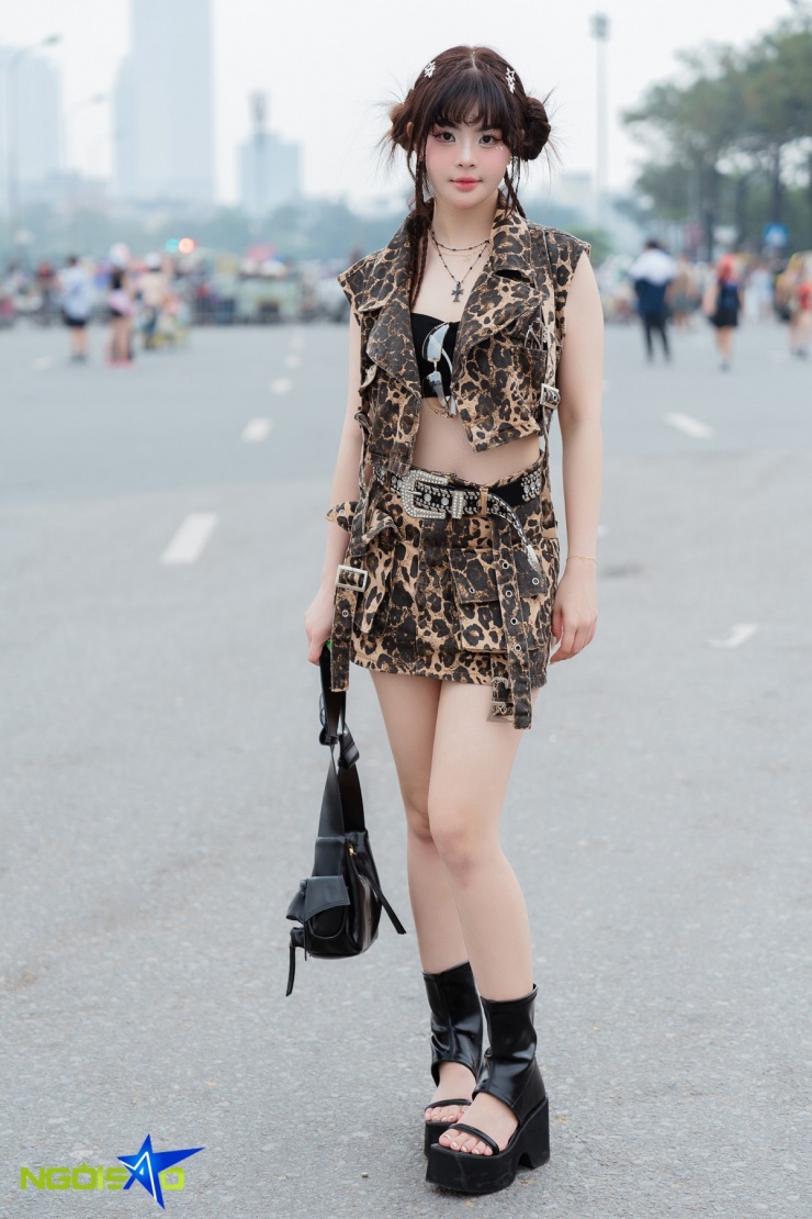 Nguyễn Thu Trang đến từ Bắc Giang, chọn phong cách punk rock pha Y2K cá tính với điểm nhấn họa tiết da báo và loạt phụ kiện nổi bật. Áo bra đen tạo hiệu ứng layer bắt mắt, tôn vòng eo. Thắt lưng đính đá bản to 'bling bling' đậm chất Y2K, kết hợp boots cao cổ đế thô hở mũi tăng vẻ hầm hố nhưng vẫn nữ tính.