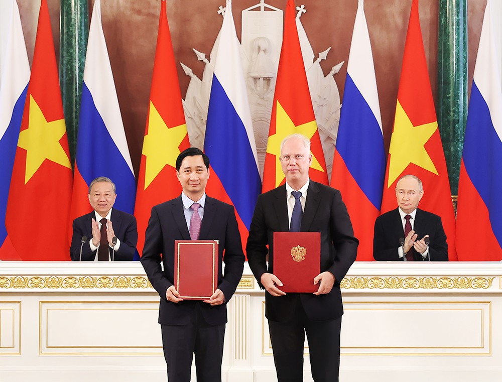 Ông Kirill Dmitriev, Đại diện đặc biệt của Tổng thống Nga về kinh tế và đầu tư nước ngoài, Tổng Giám đốc Quỹ Đầu tư Trực tiếp Nga (RDIF) đại diện phía Nga trao đổi văn kiện hợp tác với ông Ngô Chí Dũng, Chủ tịch kiêm Tổng Giám đốc Công ty Vắc xin VNVC trước sự chứng kiến của Tổng thống Nga Putin và Tổng Bí thư Tô Lâm. Ảnh: Hoàng Thống Nhất