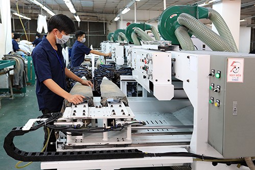 Công nhân đang thực hiện công đoạn chà xù vải tại nhà máy của VitaJean. Ảnh: Việt Thắng
