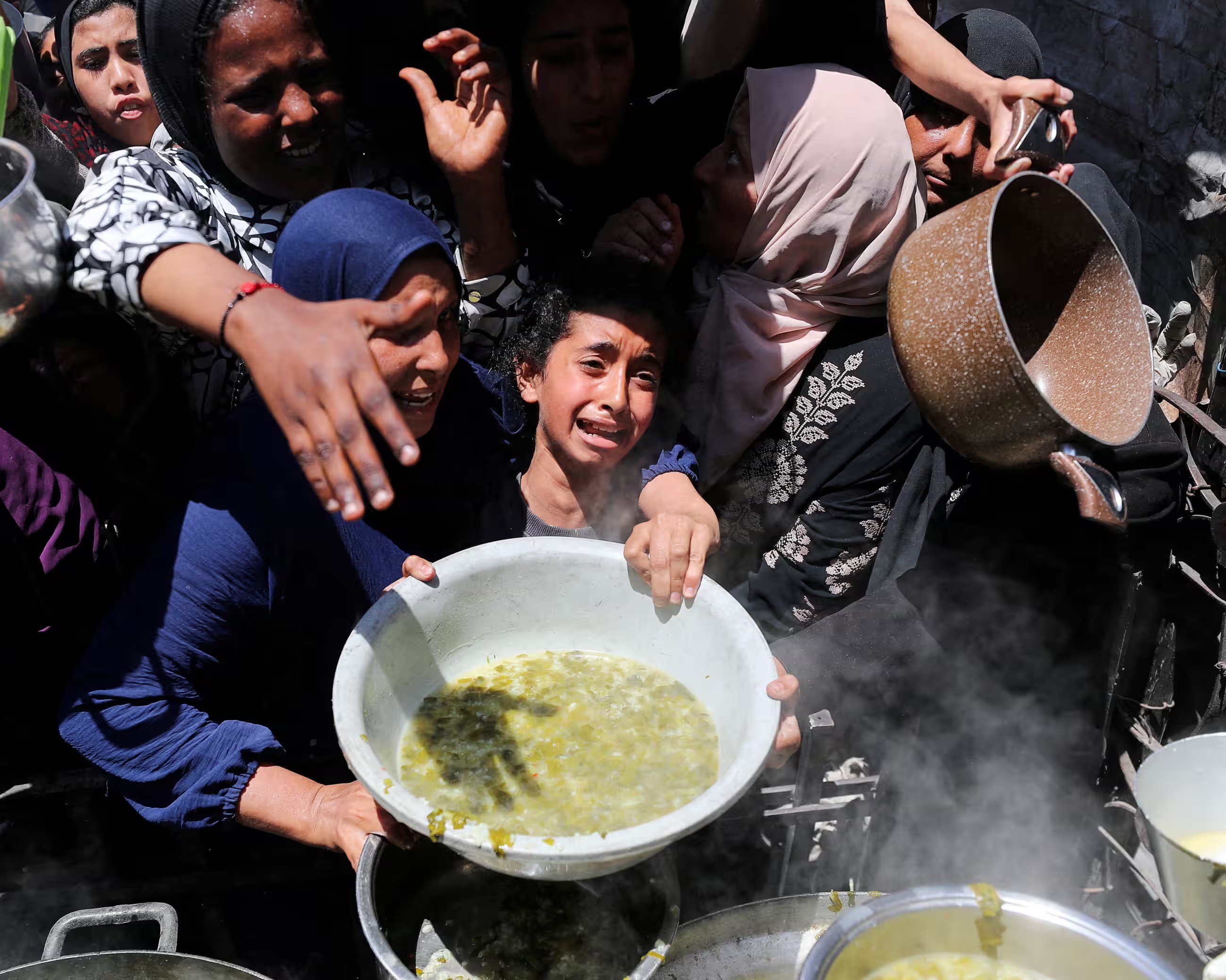 Người Palestine nhận thức ăn từ thiện ở Dải Gaza (ảnh: Reuters)