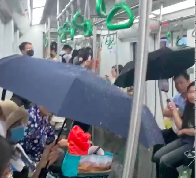 Cảnh người dân phải lấy ô che trên chuyến tàu metro Cát Linh- Hà Đông vào chiều tối 19-5. Ảnh cắt từ clip
