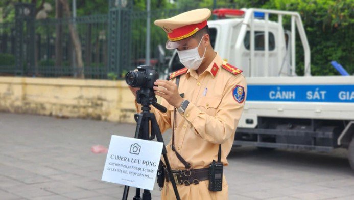Tổ công tác sử dụng máy quay để ghi hình phạt nguội người điều khiển xe máy vi phạm trật tự, an toàn giao thông tại nút giao Trần Duy Hưng - Hoàng Đạo Thúy (quận Cầu Giấy, Hà Nội).