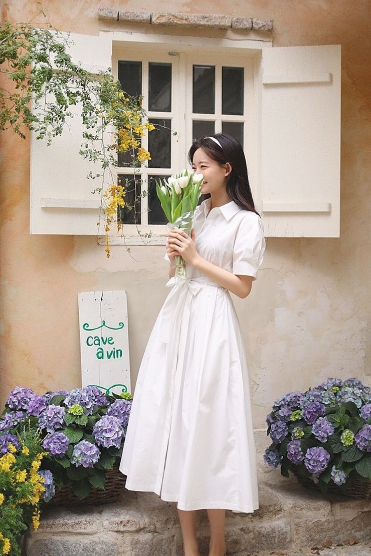 Sự kết hợp giữa váy sơ mi trắng và giày búp bê thể hiện vẻ trong sáng, không phô trương và tự nhiên. Cách phối giúp người mặc nổi bật mà không cần thêm phụ kiện nào.