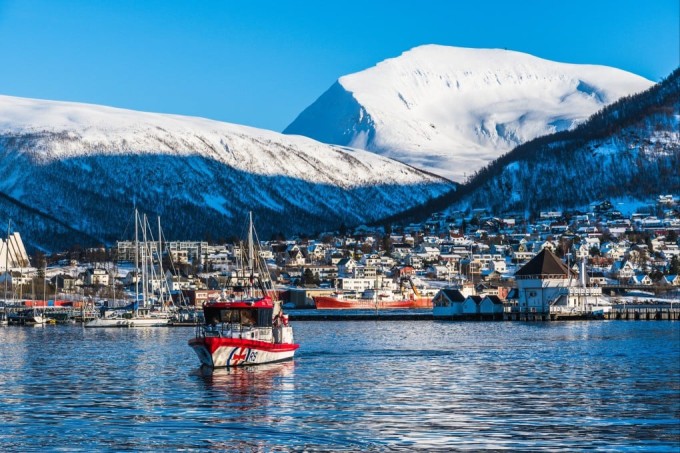 Tromsø nhìn từ ngoài biển với những ngôi nhà mái đỏ và núi phủ tuyết quanh năm. Ảnh: SCMP