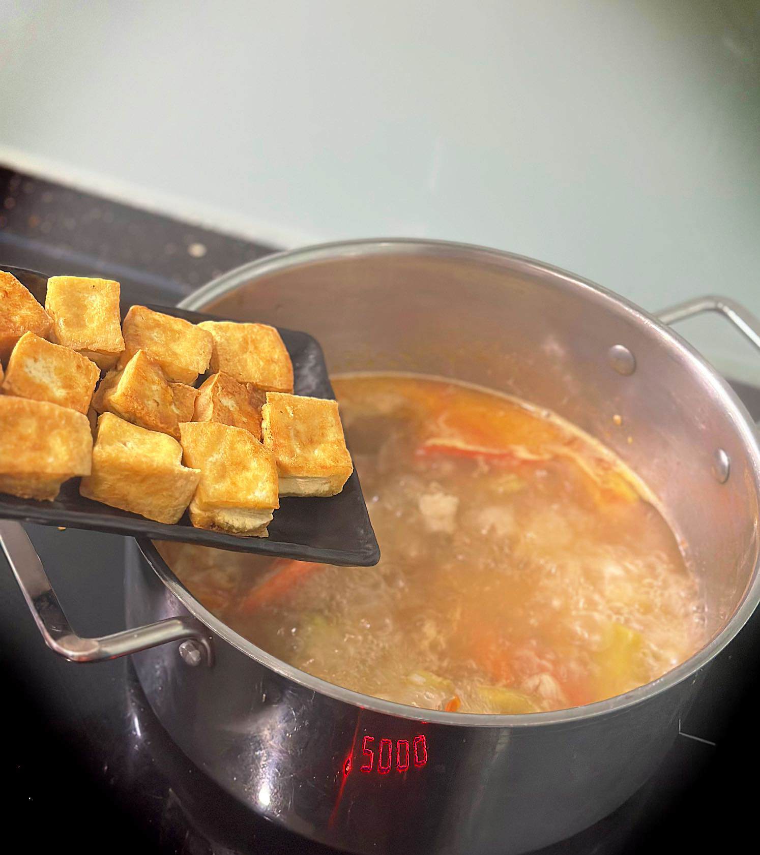 Cho đậu chiên cùng mẻ vào đun sôi tầm 15-20 phút. Khi các nguyên liệu chín, cho hỗn hợp rau thơm&nbsp;vào nồi canh, tắt bếp đảo đều, nêm thêm gia vị vừa ăn.