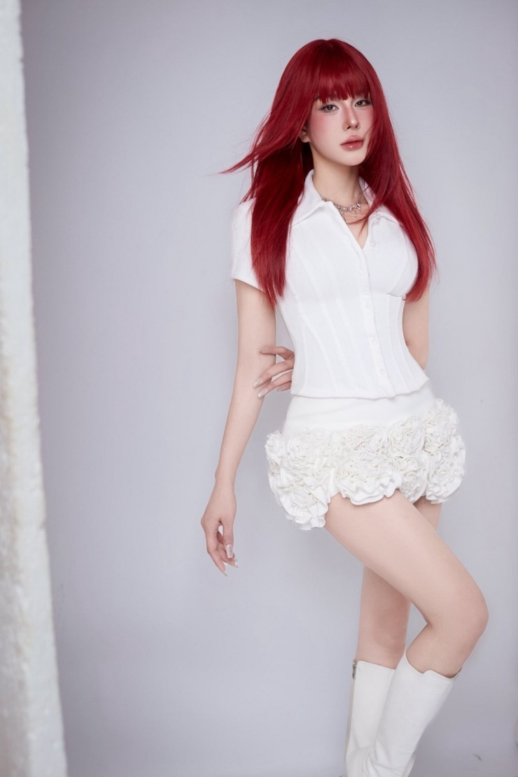 Trong bộ ảnh mới nhất, cô diện outfit trắng tinh khôi gồm áo sơ mi ôm dáng và chân váy hoa 3D, tạo nên sự tương phản mạnh mẽ với màu tóc nổi bật, mang lại vẻ ngoài hiện đại, quyến rũ và đầy khí chất.
