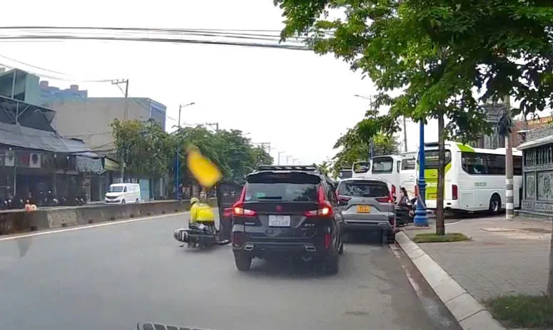 Nam tài xế công nghệ bị hất văng ra ngoài, may mắn không có đông phương tiện lưu thông cùng chiều. Ảnh cắt từ clip.
