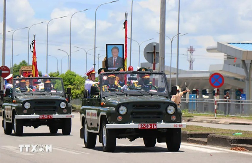 Khoảng 11 giờ 30 phút, linh xa bắt đầu rời sân bay Chu Lai ra Quốc lộ 1A thuộc xã Tam Nghĩa, huyện Núi Thành, đưa linh cữu nguyên Chủ tịch nước Trần Đức Lương di chuyển về nghĩa trang quê nhà ở xã Phổ Khánh, thị xã Đức Phổ. Ảnh: TTXVN