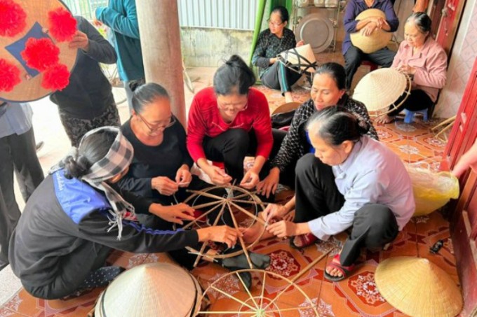 Nghệ nhân xóm Giải Tây, Bình Lục, Hà Nam đan nón lá. Ảnh: Asahi