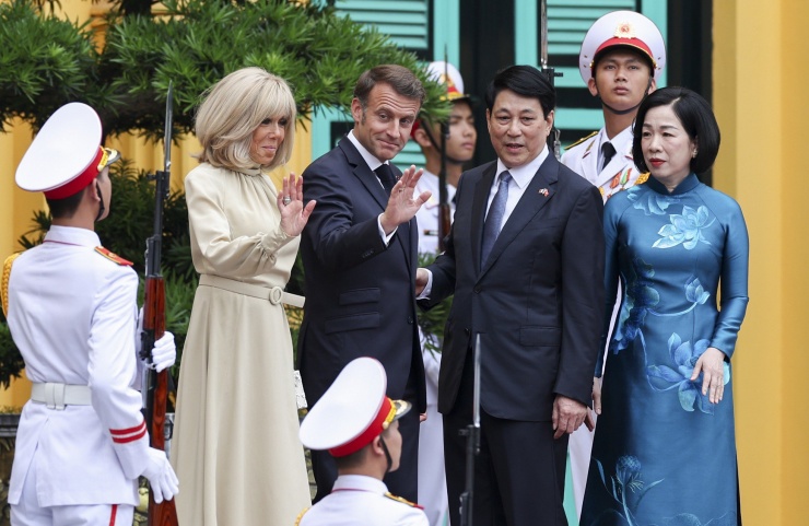 Ngày 26/5, trong lễ đón chính thức tại Phủ Chủ tịch, phu nhân Brigitte Macron mặc váy midi màu ngà dài qua gối, với phần cổ cao và có thắt lưng. Bà phối với giày cao gót mũi nhọn đồng bộ và ví cầm tay màu trắng. Ảnh: AP