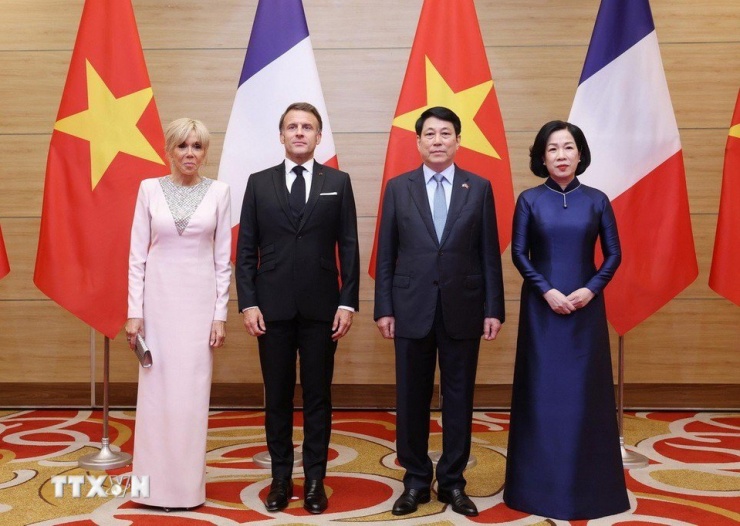 Tại tiệc chiêu đãi vào cùng ngày, bà chọn váy hồng nhạt dài tay, có thêm phần cổ ren trắng. Theo Elle, phu nhân Brigitte Macron không có ngoại hình xuất chúng, nhưng biết cách thu hút ánh nhìn bởi phong cách chỉn chu và có thẩm mỹ riêng. Ảnh: TTXVN.