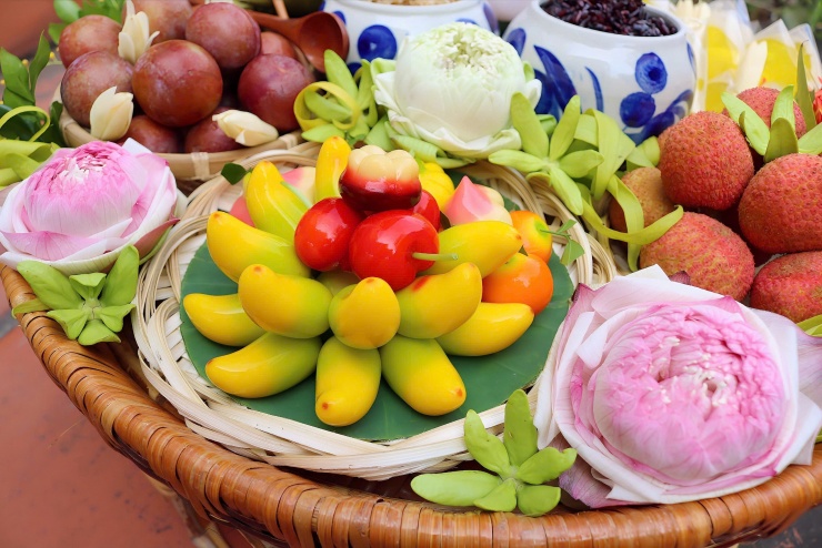 Mâm quả ngũ sắc trung tâm: Những quả chuối dẻo vàng óng, xen kẽ quả hồng dẻo đỏ rực, cam quýt dẻo, được sắp xếp thành chùm hoa rực rỡ, gợi hình bông sen ngũ sắc.