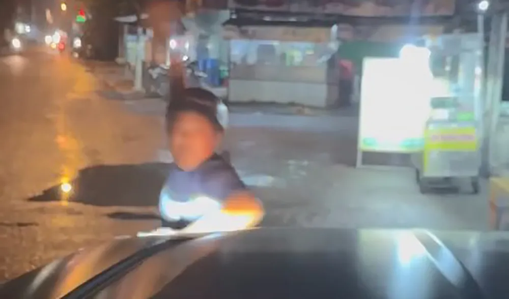Sau khi chửi bới qua lại, một người đàn ông đã cầm đá ném vào kính chắn gió. Ảnh cắt từ clip