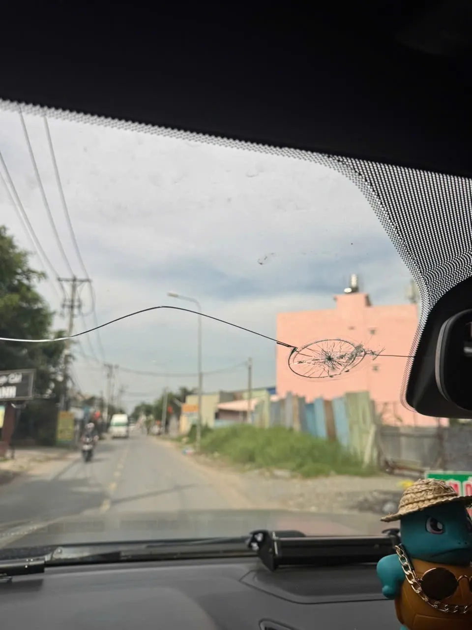 Một trong hai người đàn ông đã dùng đá ném vào kính chắn gió. Ảnh: NNCC