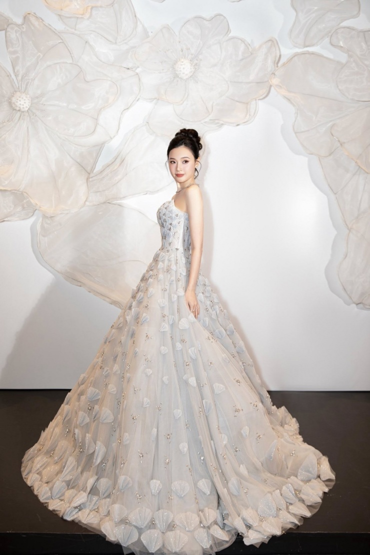 Xuất hiện trên thảm đỏ show thời trang Veil of the Desert gần đây, Midu hóa công chúa cùng chiếc váy xòe bồng tốn cả trăm mét vải. Thiết kế được tô điểm bằng những hạt pha lê lấp lánh cùng các cánh hoa đan xen đính kết thủ công, giúp Midu trông như bước ra từ cổ tích.