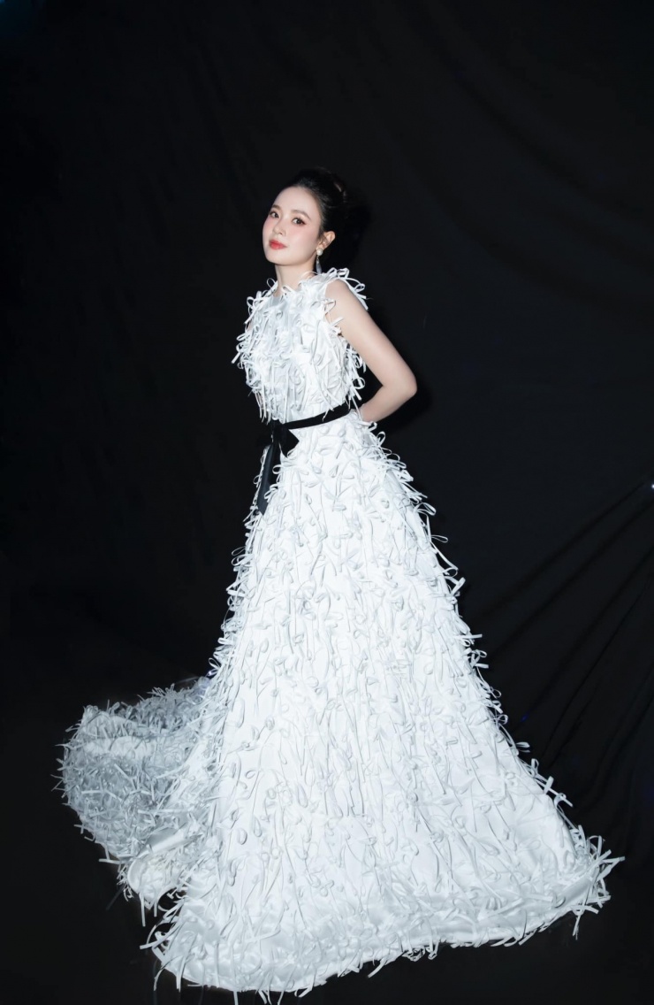 Khi tham dự show của NTK Hà Thanh Việt, Midu tạo sự nổi bật qua mẫu váy dài quét đất, tốn hàng chục mét vải. Trên thân váy, cả trăm chiếc nơ nhỏ xinh được đính kết thủ công để tôn dáng vẻ yểu điệu của 'nàng dâu hào môn'.