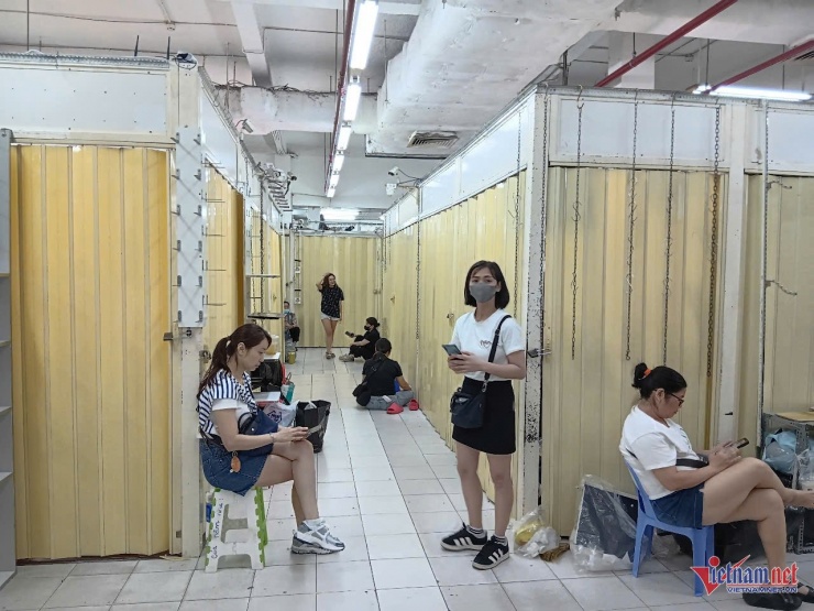 Dù đóng cửa nhưng, chủ các ki-ốt vẫn đứng ngồi xung quanh để nghe ngóng tình hình.